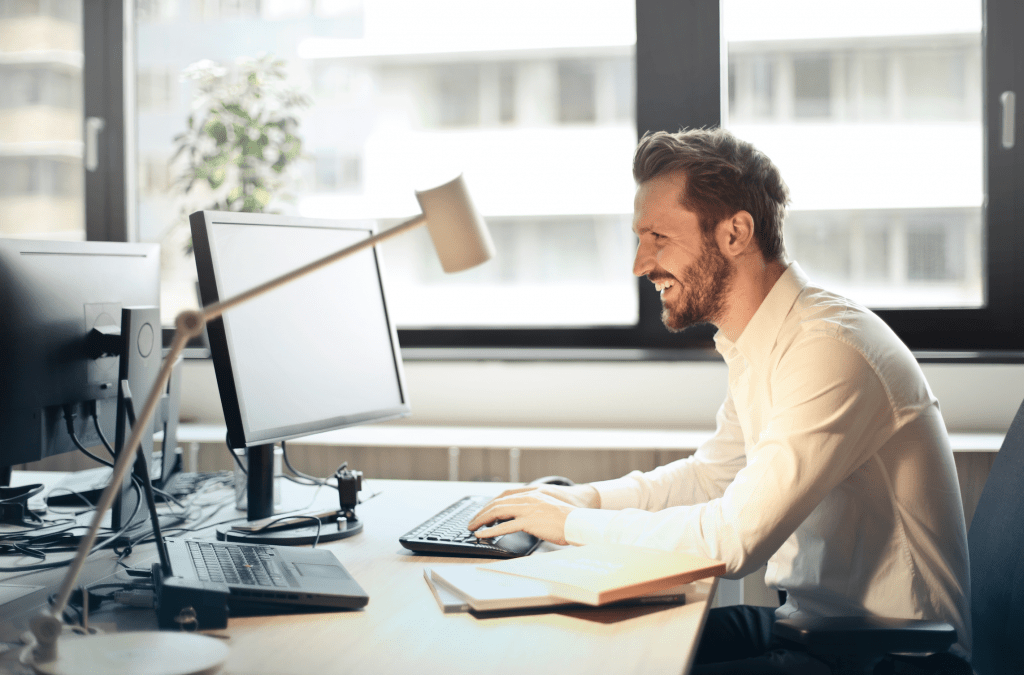 Man laughing at computer screen