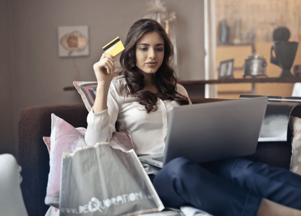 photo of woman sitting on couch with credit card